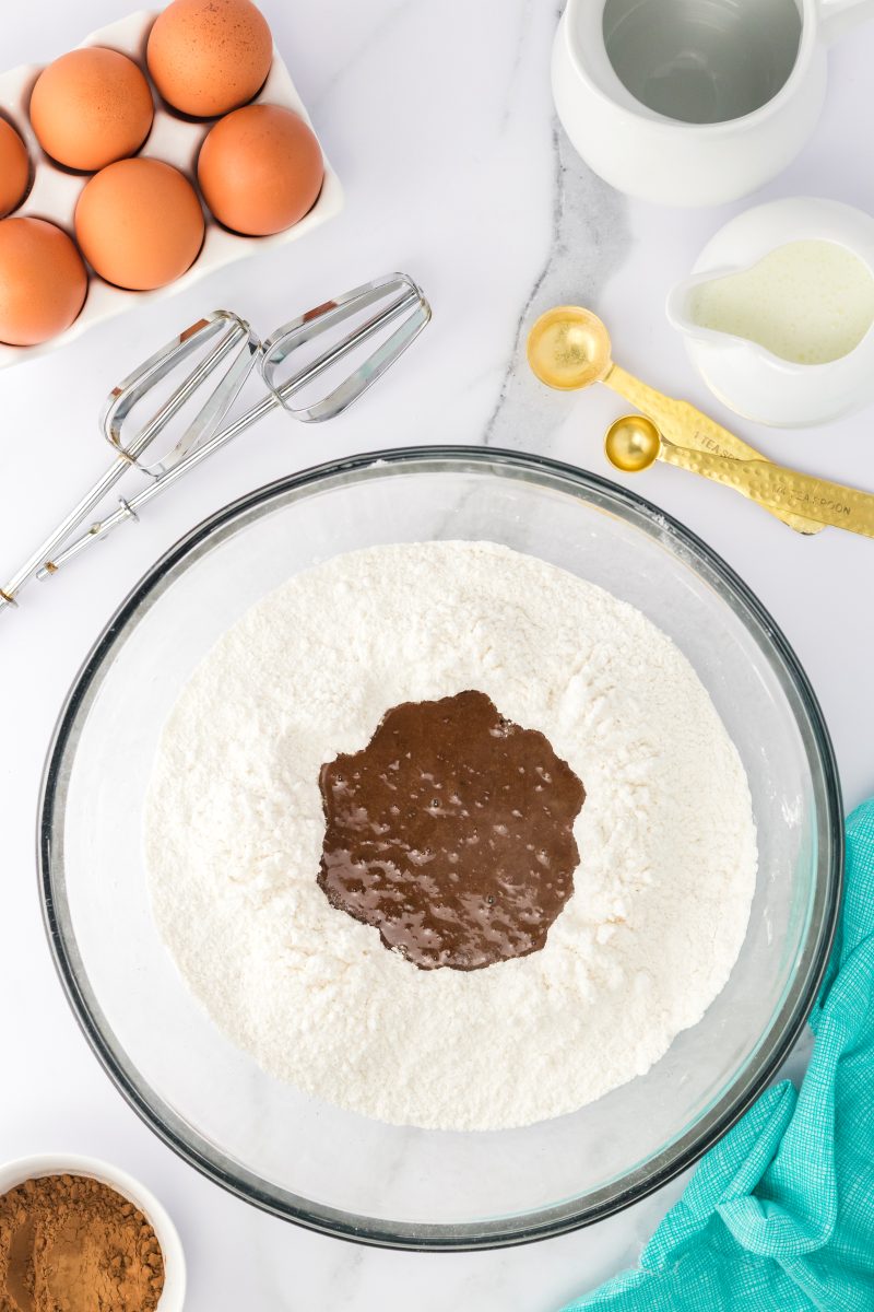 Mixing bowl filled with powdered sugar with a chocolate mixture added to the center - Hostess At Heart