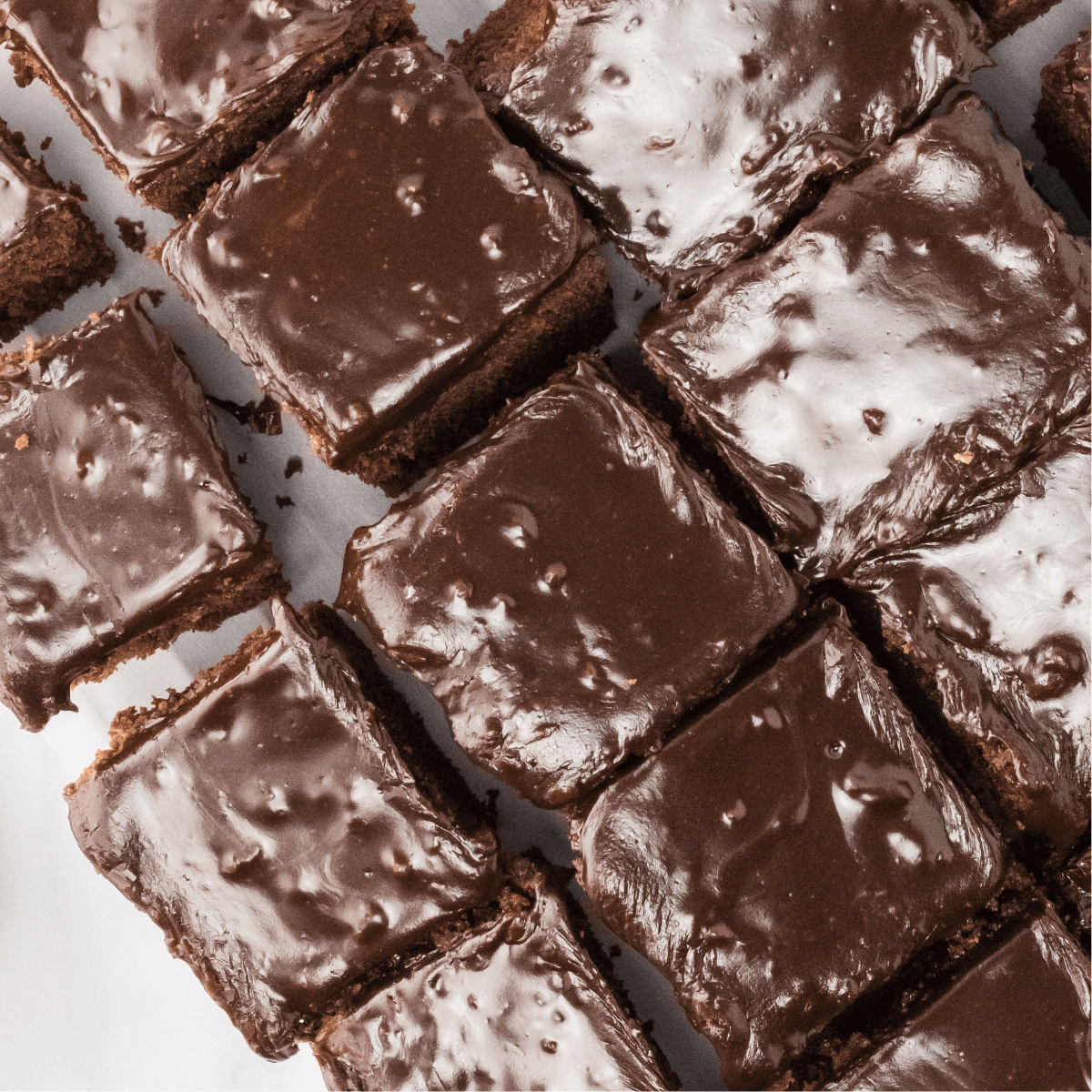 Top down view of cut pieces of chocolate buttermilk brownies topped with dark chocolate icing - Hostess At Heart