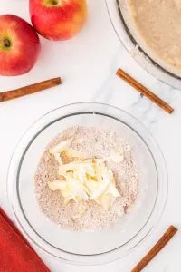 Cold butter shavings added to flour, sugar, and cinnamon in a bowl to make a crumb topping. Hostess At Heart