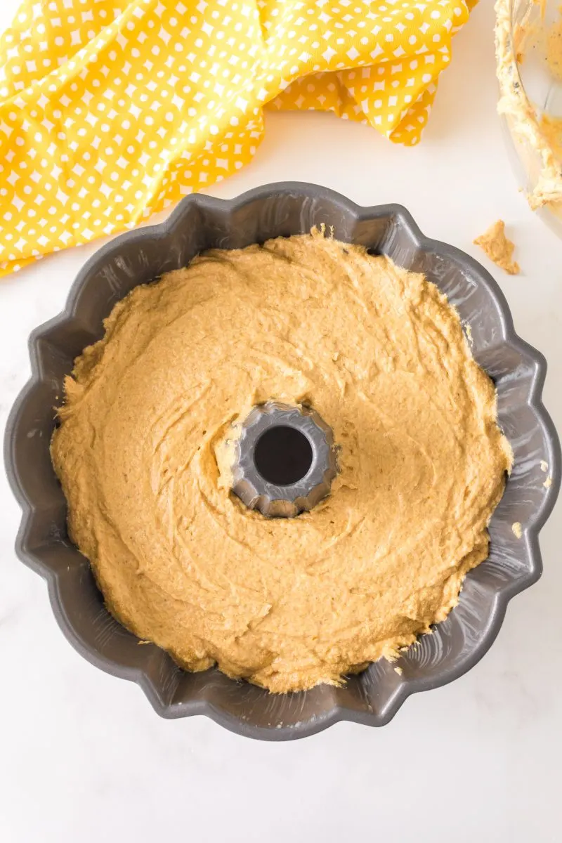 A prepared bundt pan filled 3/4 full of cake batter. Hostess At Heart