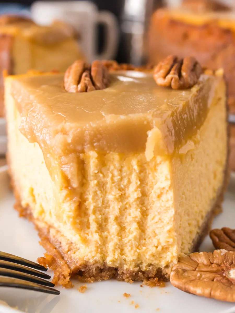 Front tableview of a slice of pumpkin pie cheesecake with the first bite taken out. Hostess At Heart