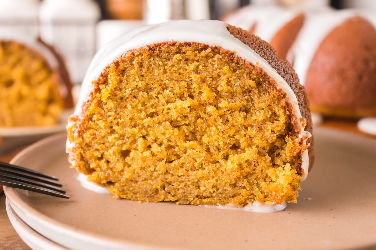 A sideview of a slice of Pumpkin Bundt Cake topped with glaze.
