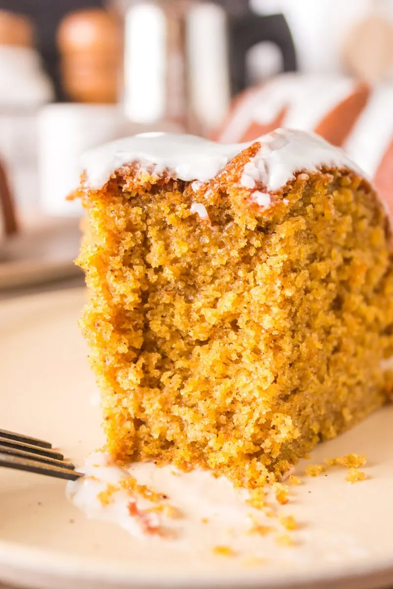 A slice of glazed spice cake with the first bite taken out of it - Hostess At Heart