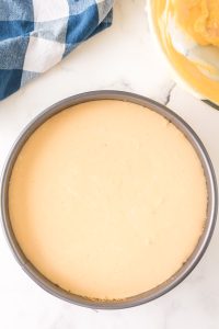 Cheesecake batter poured over a graham cracker crust in a springform pan - Hostess At Heart