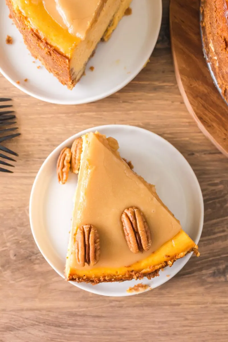 Top down view of a slice of pumpkin praline cheesecake topped with toasted pecans - Hostess At Heart