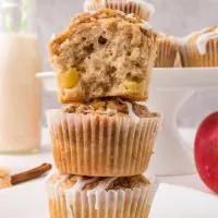 A stack of three glazed muffins with a bite taken out of the top one. Hostess At Heart
