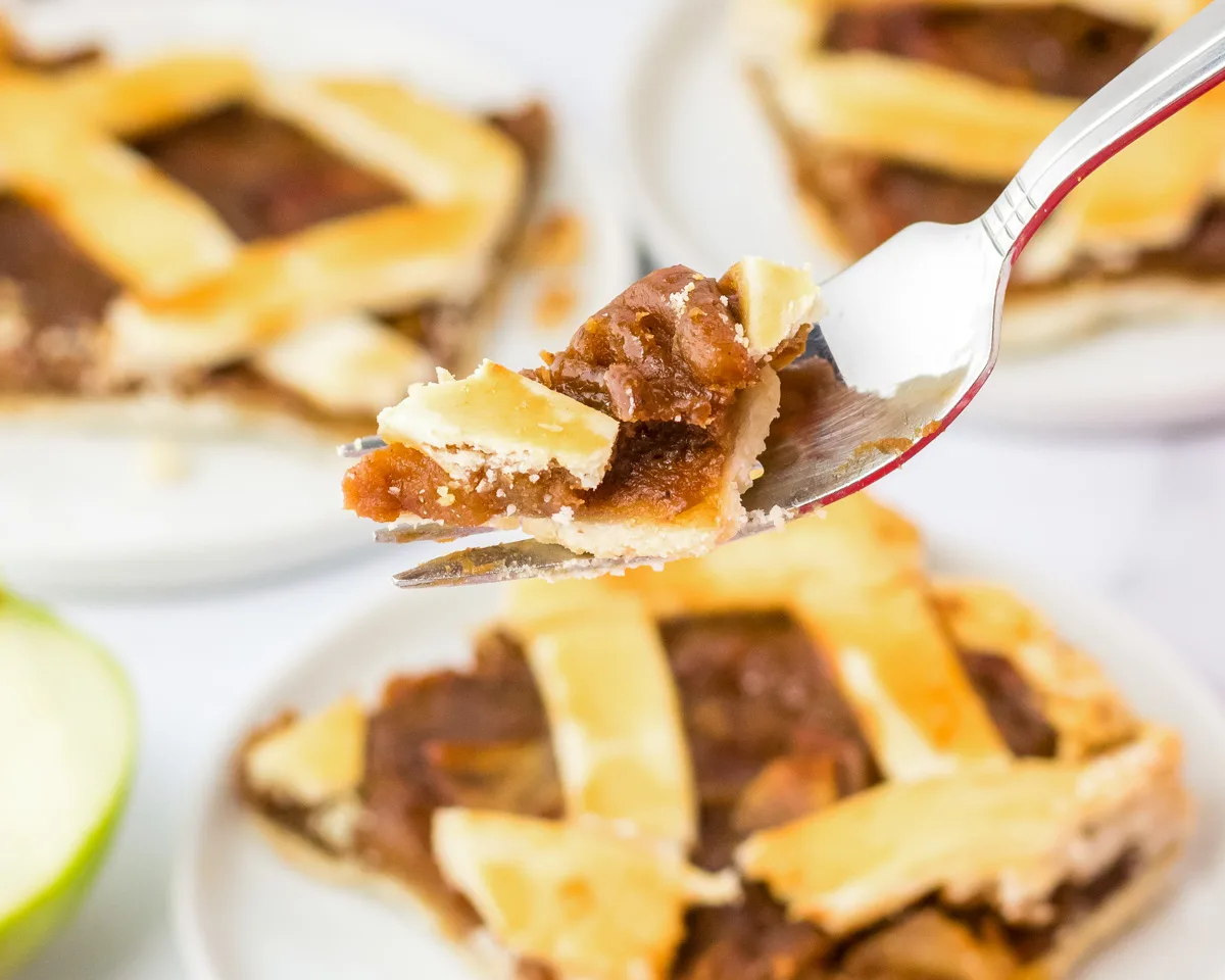 Side view of a fork lifting a bite of caramel apple pie. Hostess At Heart