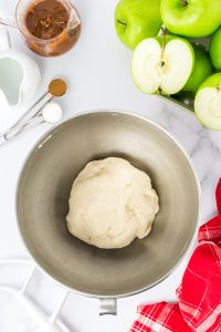 A ball of pie crust dough sitting in a mixing bowl - Hostess At Heart