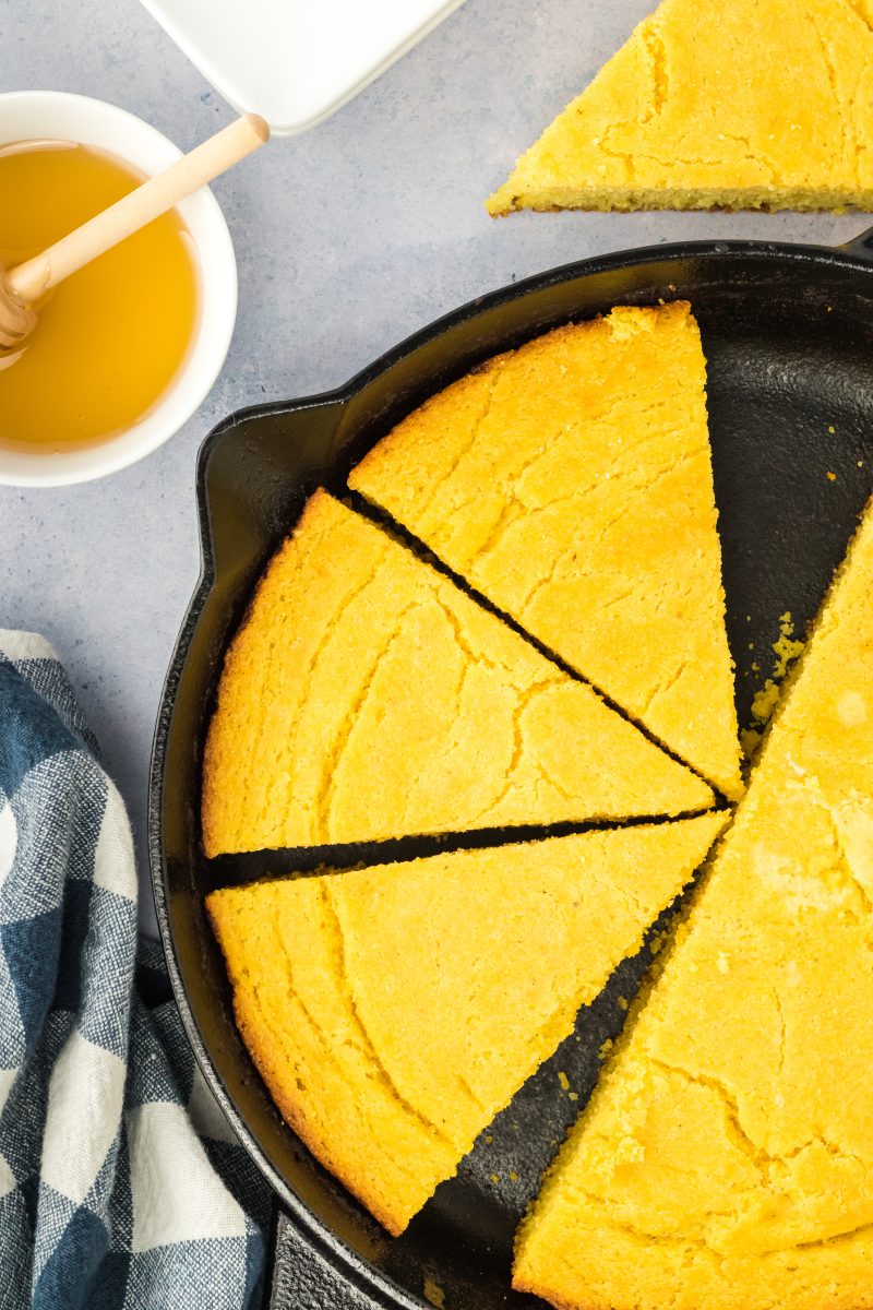 Top down view of a partially sliced skillet of cornbread - Hostess At Heart