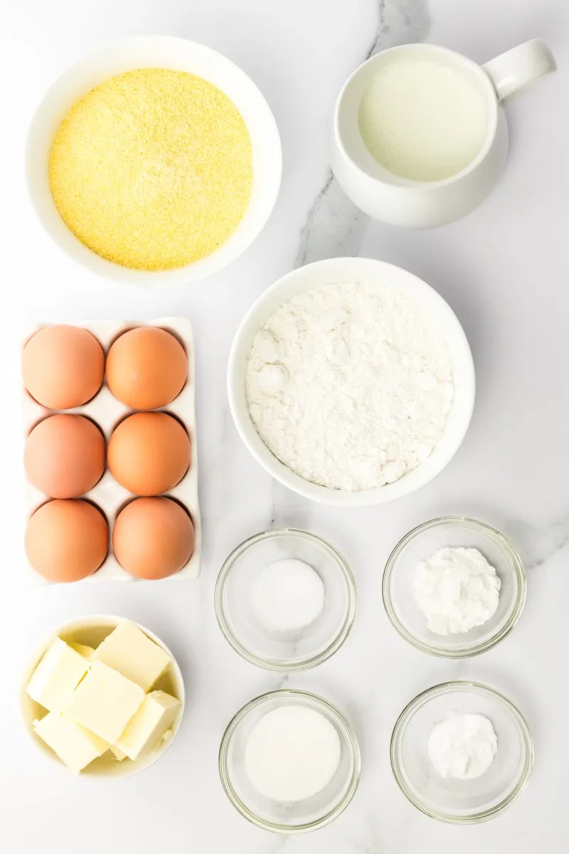 Top down view of cornbread ingredients including butter, sugar, salt, baking powder, baking soda, corn meal, flour, and buttermilk