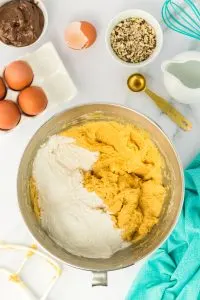 An electric mixing bowl filled with pumpkin batter and flour - Hostess At Heart