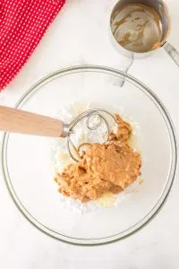 Peanut butter, melted butter, and powdered sugar added together in a mixing bowl - Hostess At Heart