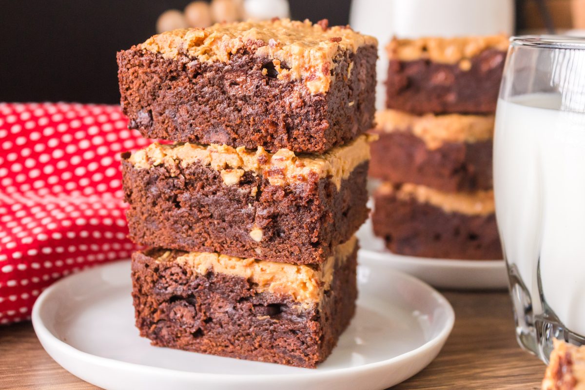The pieces of peanut butter brownies stacked on each other - Hostess At Heart
