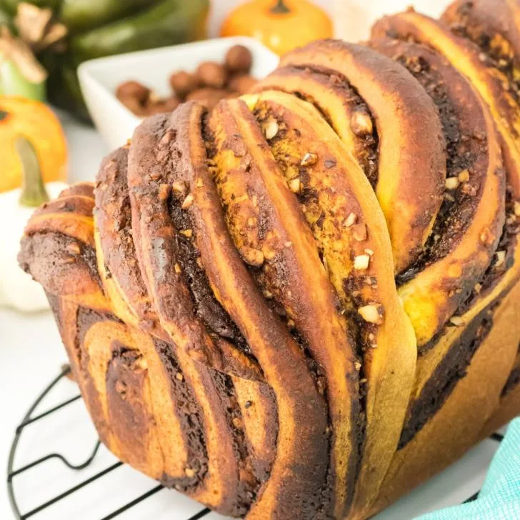 An angled view of bread swirled with ribbons of chocolate and pumpkin dough. Hostess At Heart
