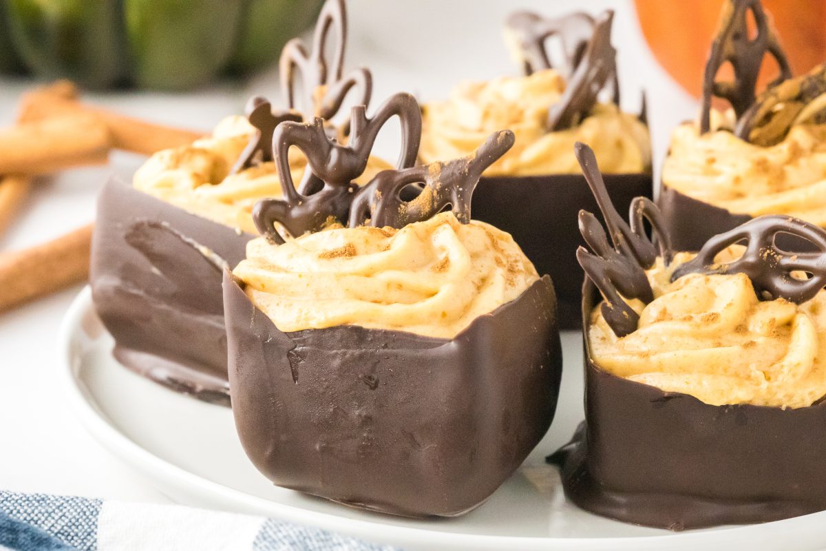 Side view of individual homemade chocolate cups filled with a no-bake pumpkin mousse - Hostess At Heart