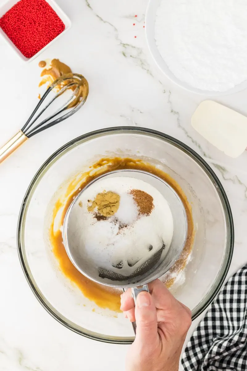 Top down view of spices and flour being sifted together over a bowl - Hostess At Heart