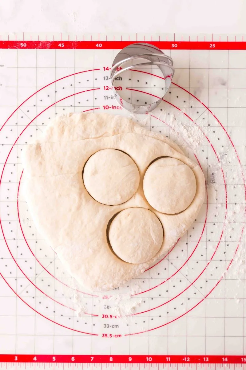 Top down view of English muffin dough being cut.