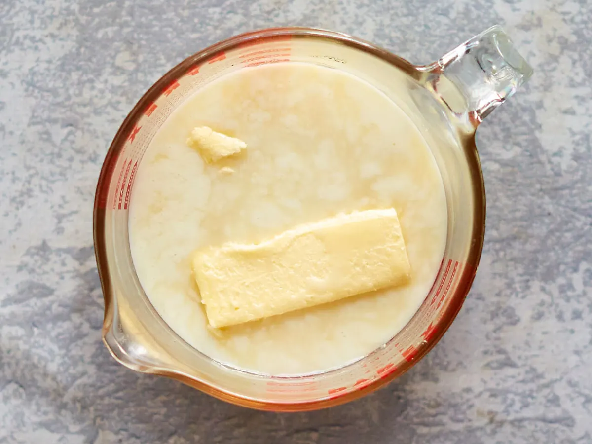 Top down view of a measuring cup filled with the wet ingredients used in a Hawaiian Bread Roll Recipe. Hostess At Heart