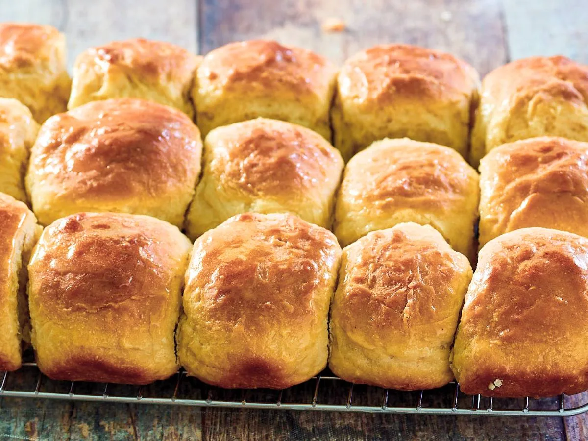 Homemade baked bread rolls sitting on a cooling rack. Hostess At Heart