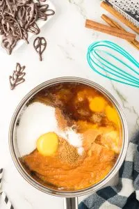 Saucepan filled with easy pumpkin mousse ingredients including pumpkin puree, eggs, sugar, and spices - Hostess At Heart