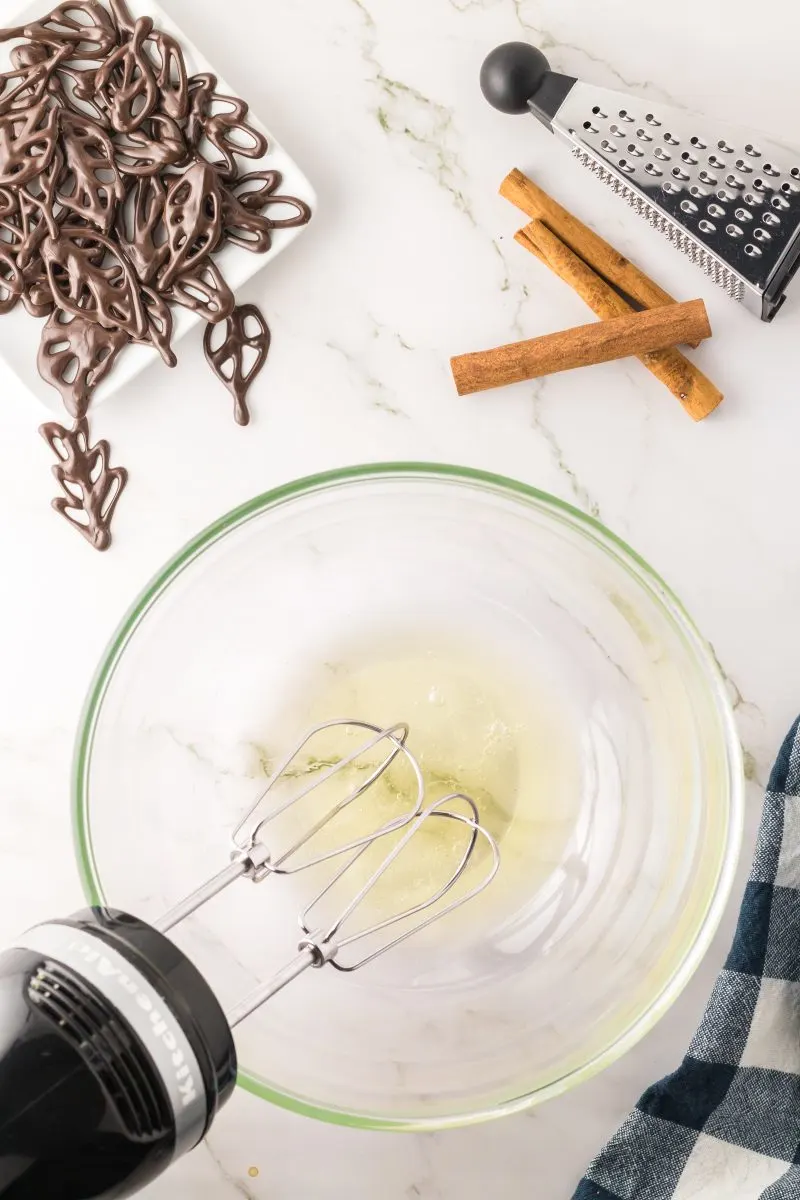 Egg whites added to a mixing bowl showing how to whip with an electric mixer - hostess at Heart