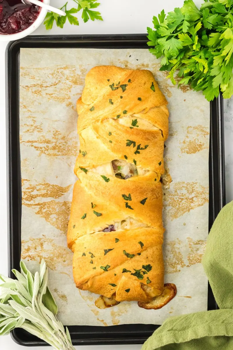 Top down view of baked Crescent Roll Braid stuffed with cheese, turkey, and cranberries. Hostess At Heart