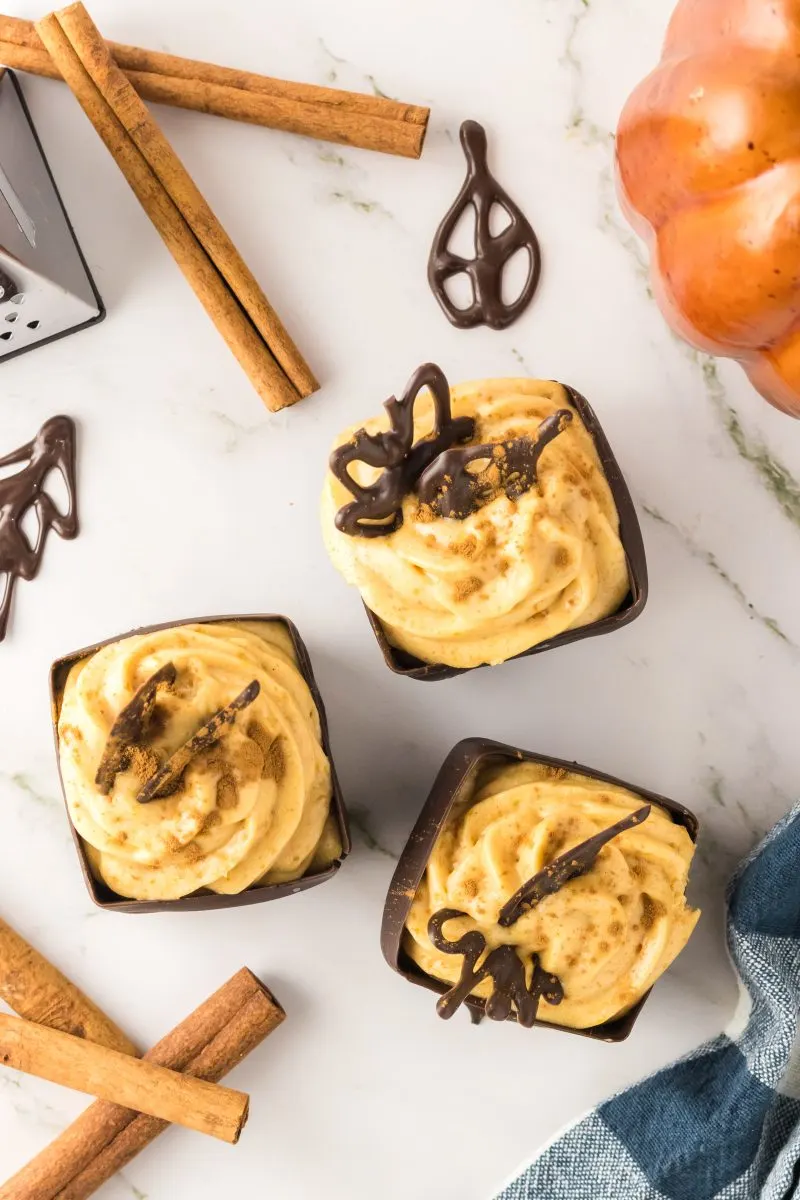 Top down view of Spiced Pumpkin Mousse filling in individual homemade chocolate cups with a chocolate topper - Hostess At Heart