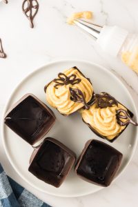 No Bake Pumpkin mousse piped into individual chocolate dessert cups - Hostess At Heart