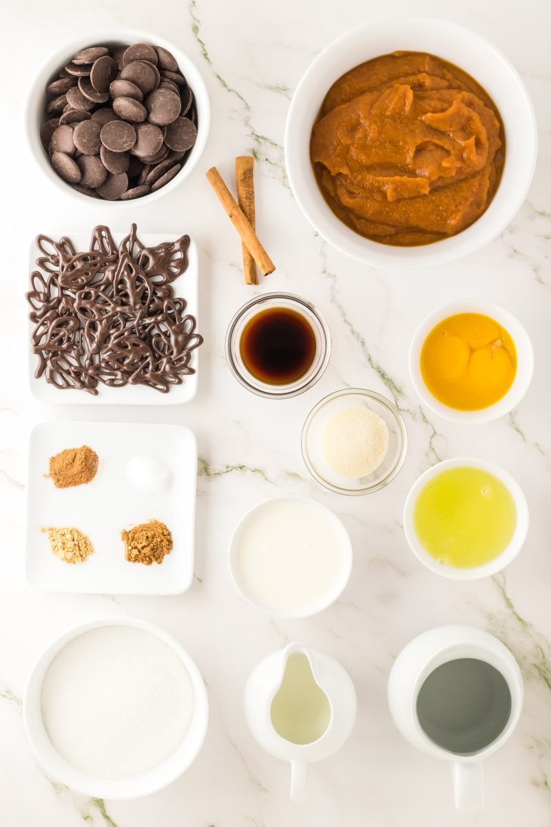Ingredients used to make creamy pumpkin mousse in chocolate cups including gelatin, pumpkin puree, sugar, chocolate pieces, spices, eggs, and vanilla - Hostess At Heart