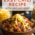 Sideview of a bowl of stovetop chili recipe garnished with freshly shredded cheddar cheese.