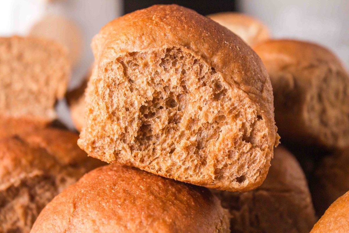 Sideview of a baked bread roll sitting on top of several rolls - Hostess At Heart