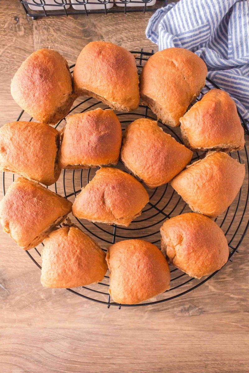 Top down view of baked brown bread rolls on a cooling rack - Hostess At Heart