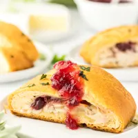 Front view of a Turkey and cheese crescent roll topped with cranberry sauce - Hostess At Heart