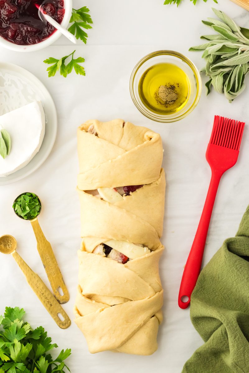 Top down view of a completed crescent roll braid stuffed with turkey and cranberries - Hostess At Heart