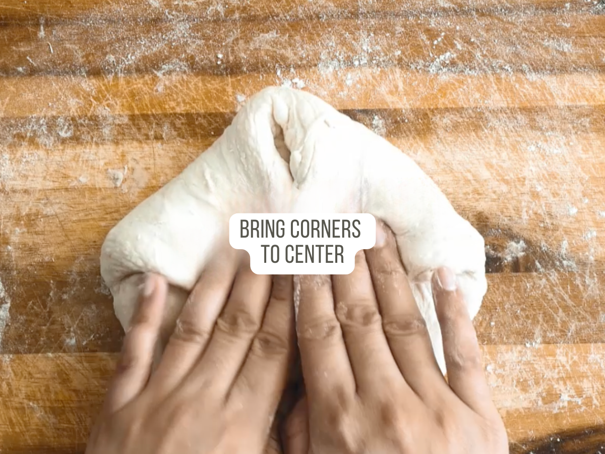 Two corners of bread dough folded to the center to make a French Batard Bread Recipe - Hostess At Heart