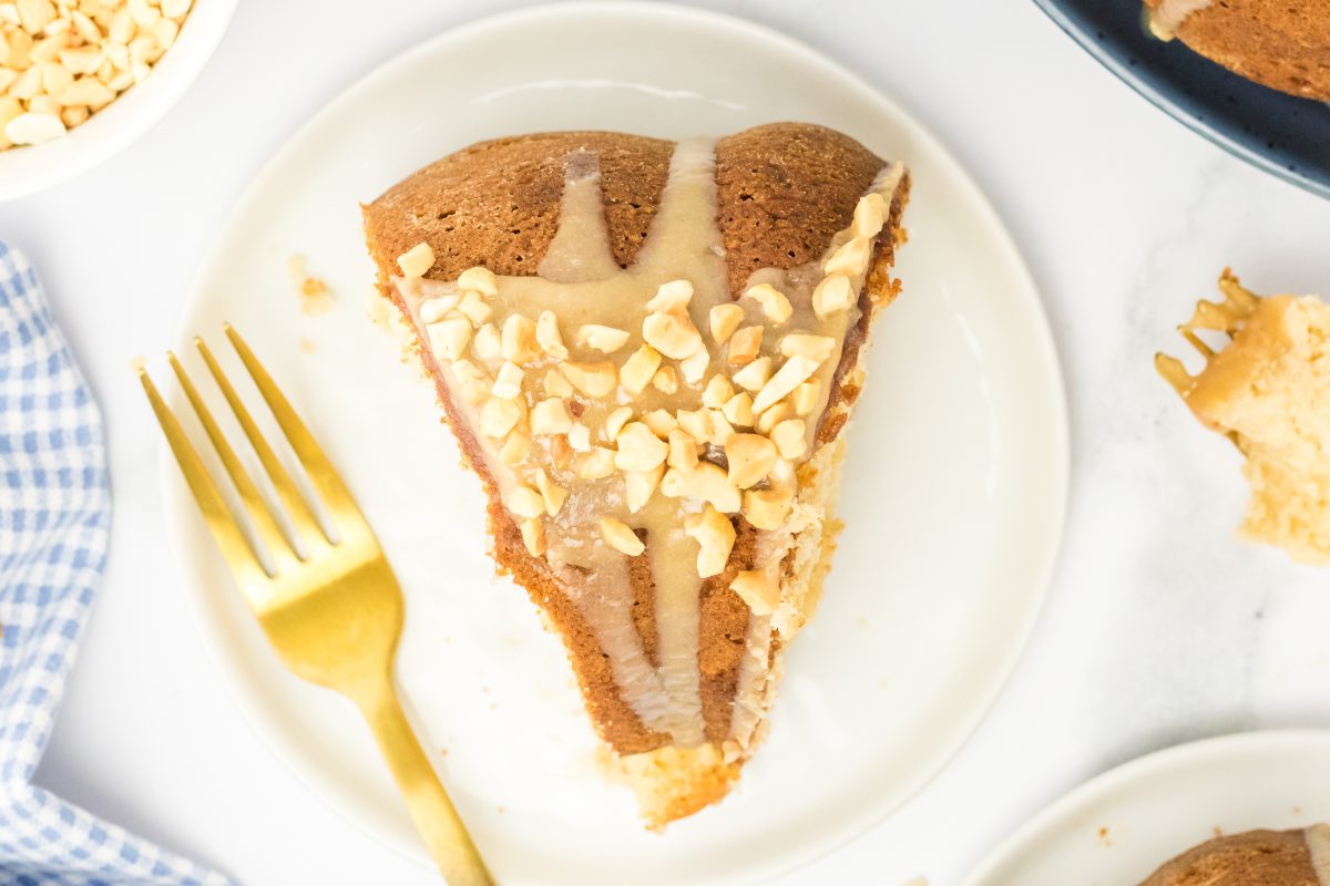 Top down view of a slice of peanut butter cake topped with glaze and chopped peanuts - Hostess At Heart