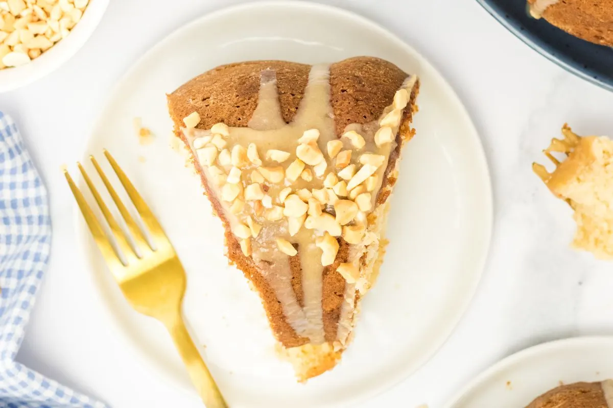 Top down view of a slice of peanut butter cake topped with glaze and chopped peanuts - Hostess At Heart