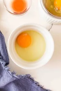 Top down view of a cracked egg in a ramekin dish - Hostess At Heart