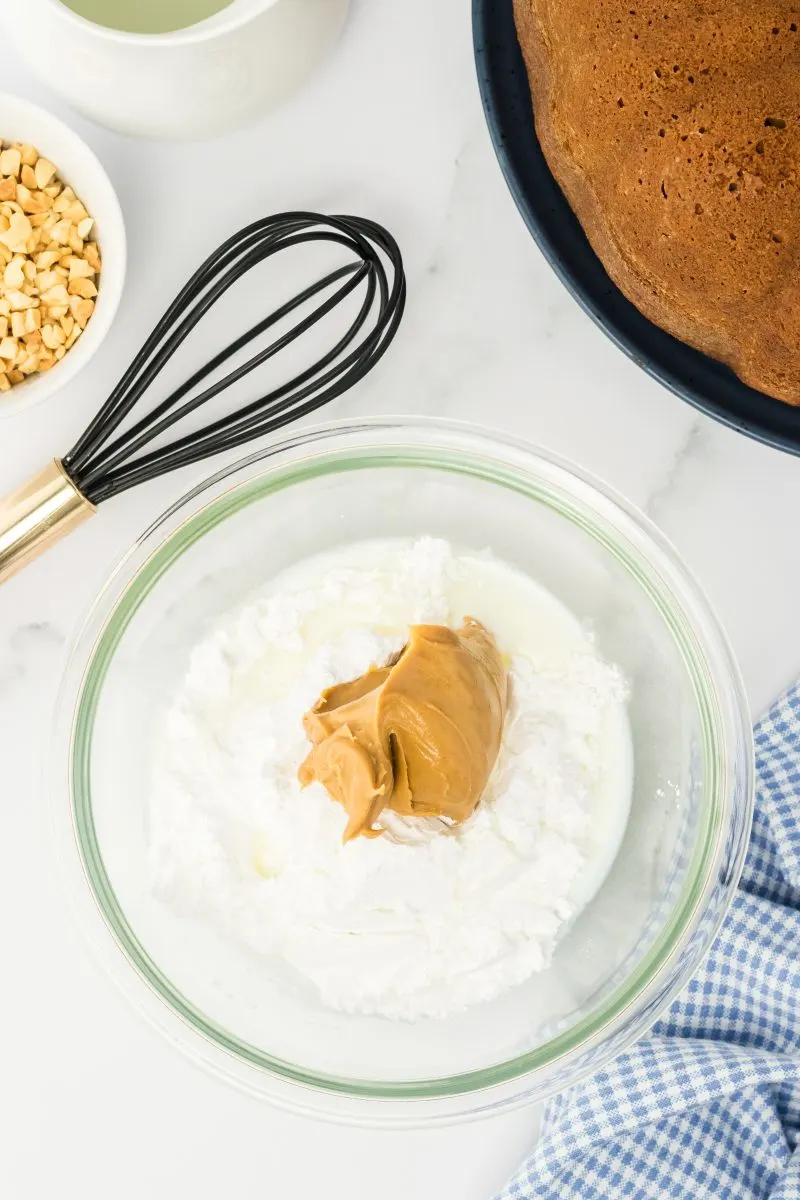 Small bowl filled with powdered sugar, peanut butter, and buttermilk for a peanut butter glaze.