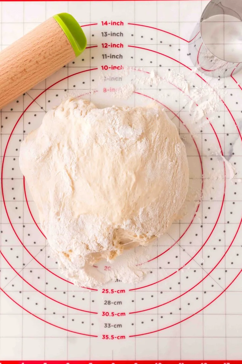 A ball of dough on a floured working surface prepared to roll - Hostess At Heart