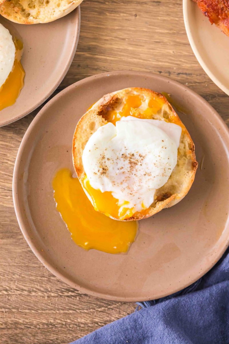 A drippy poached egg sitting on a toasted English Muffin - Hostess At Heart