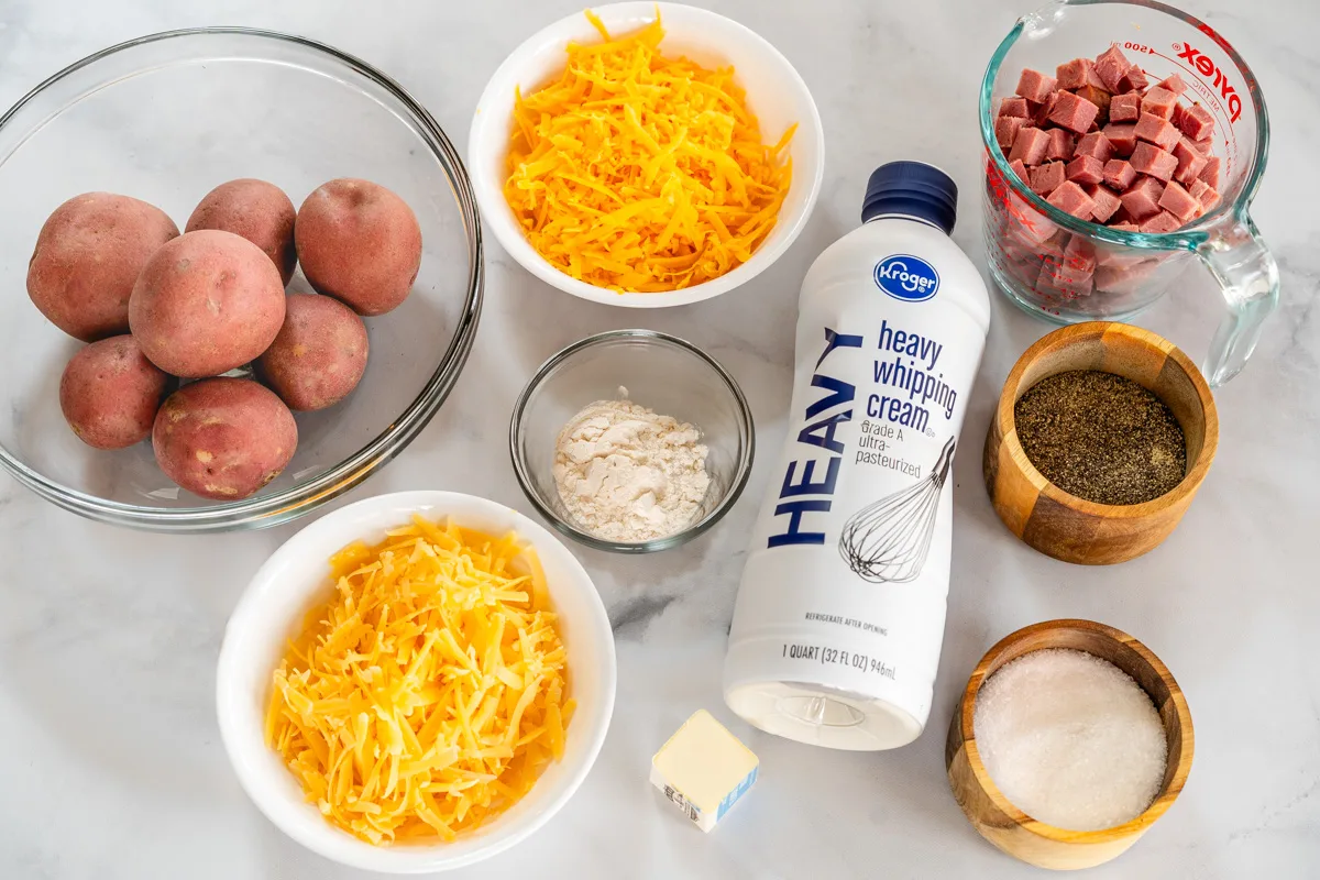 Ingredients for Corned Beef Potatoes Au Gratin: Potatoes, gouda cheese, corned beef cubes, cheddar cheese, flour, heavy whipping cream, butter, salt and pepper.