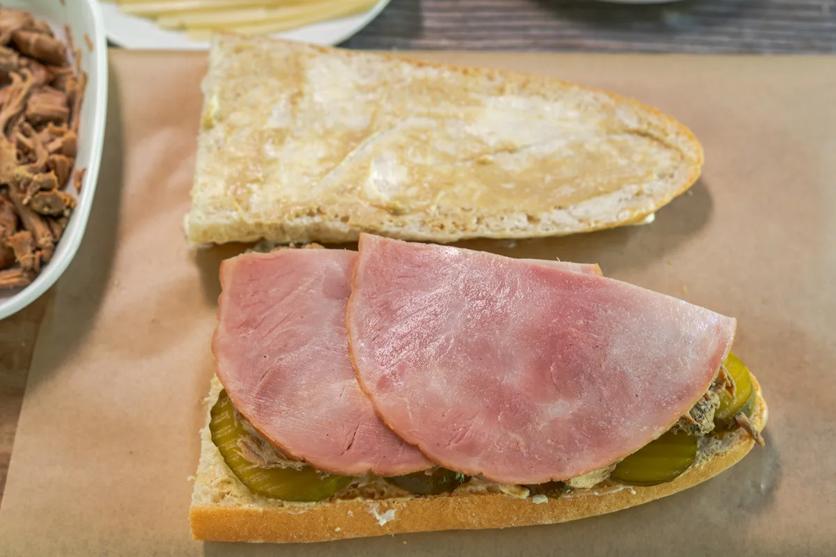 Deli ham slices on top of shredded pork to make a Cuban Sandwich - Hostess At Heart