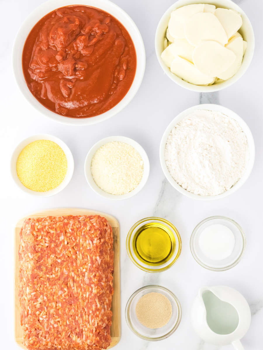 Ingredients required to make Chicago Deep Dish Pizza recipe including Pizza Sauce, Mozarella, parmesan, cornmeal, flour, salt, oil, yeast, water, sausage. Hostess At Heart
