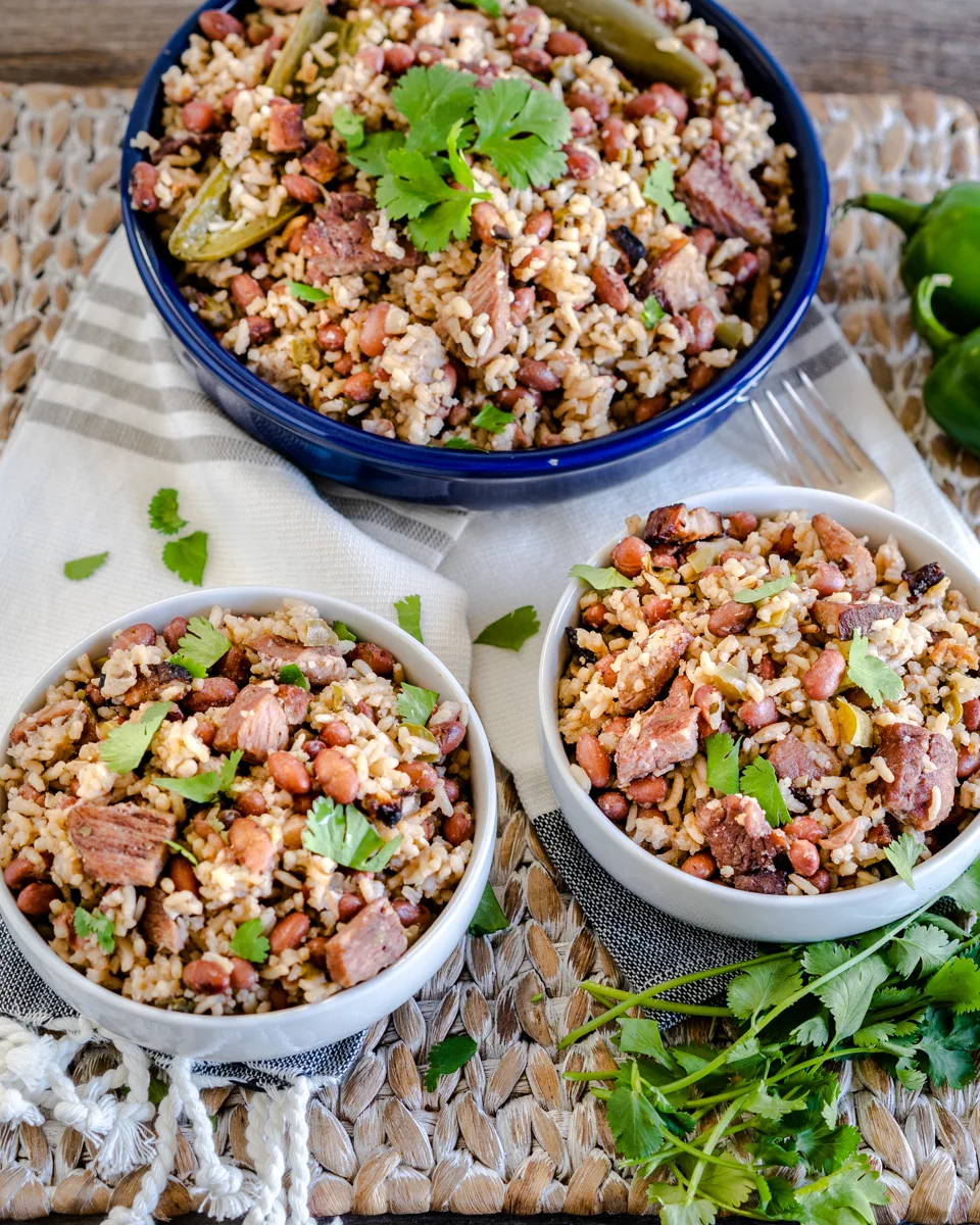 Two bowls filled with Rice and red beans with chunks of ham - Hostess At Heart