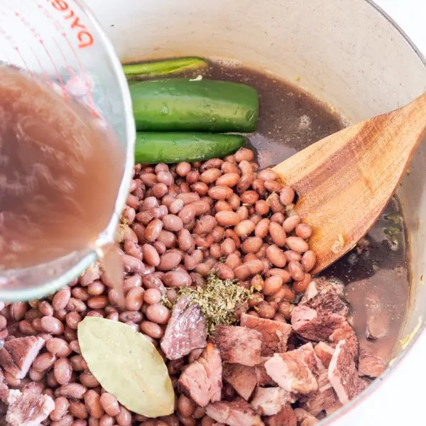 Homemade stock added to ingredients used to make Cuban Beans and Rice - Hostess At Heart