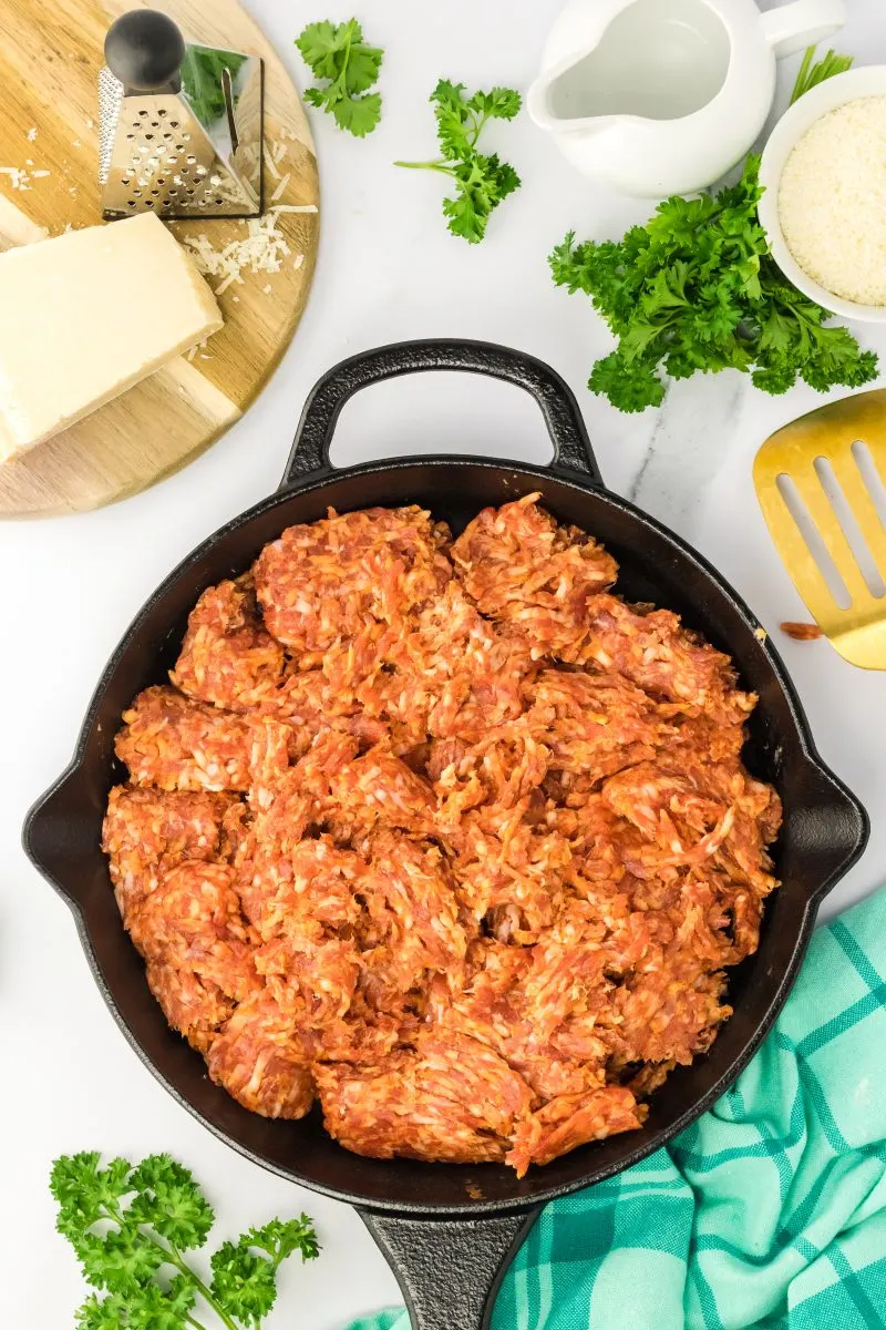 Ground sausage being cooked in a cast iron skillet