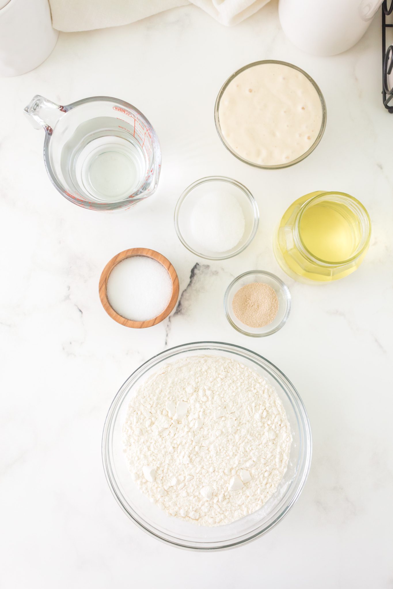 Ingredients used to make same day sourdough focaccia bread including starter, flour, yeast, salt, water, and olive oil. Hostess At Heart