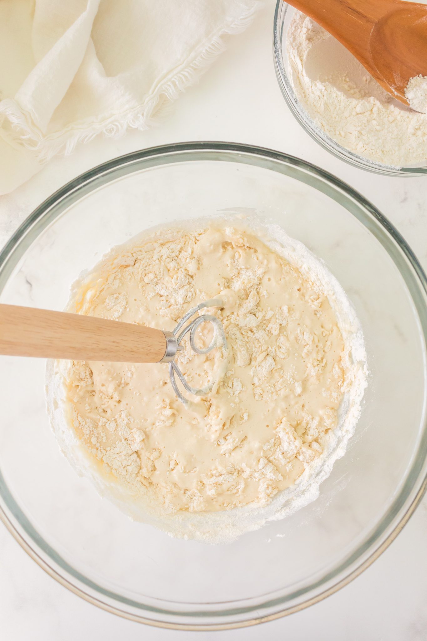 Flour added to wet sourdough ingredients in a mixing bowl - Hostess At Heart