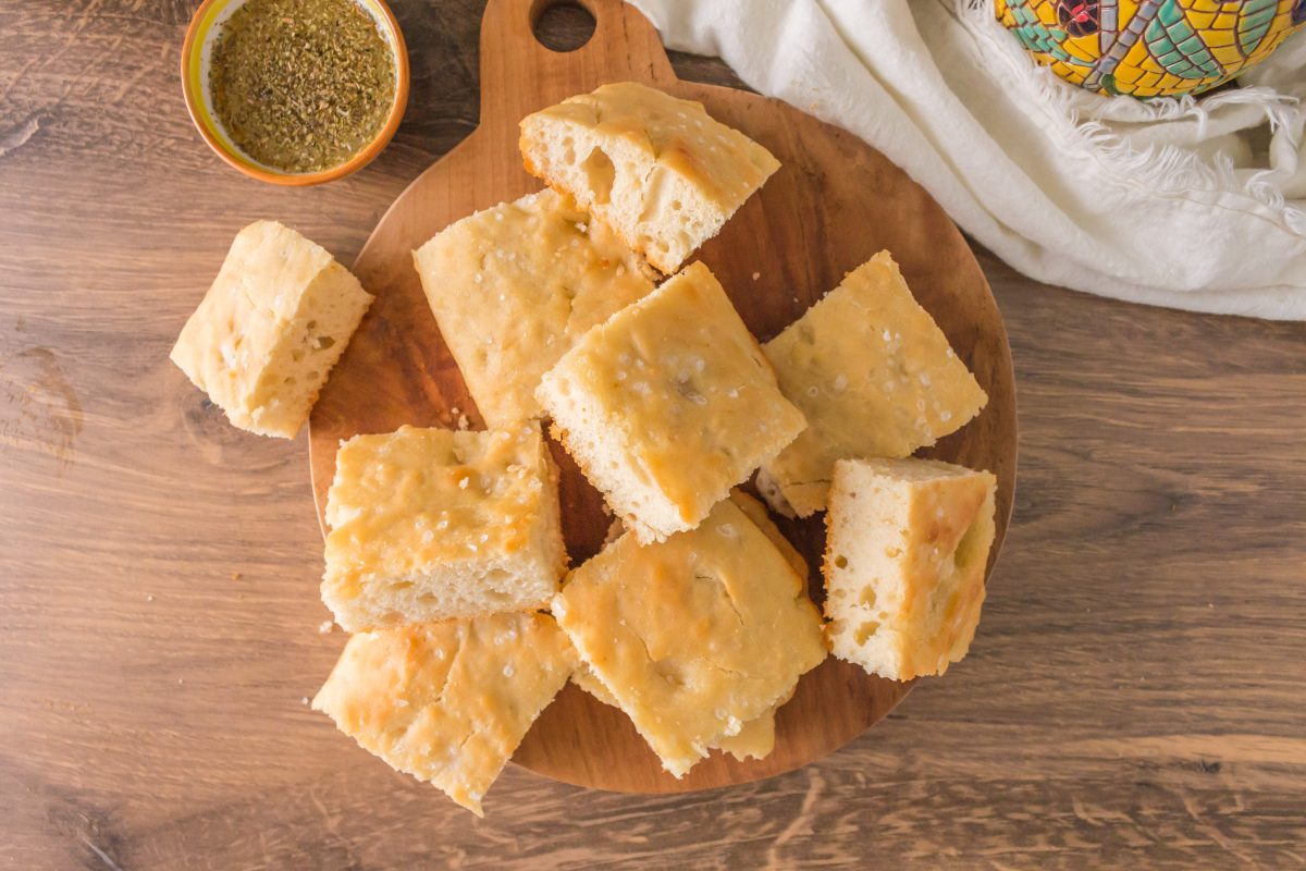 Top down view of pieces of sourdough focaccia sitting on a cutting board - Hostess At Heart